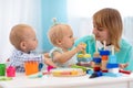 Nursery teacher looking after children in daycare. Little kids toddlers play together with developmental toys. Royalty Free Stock Photo