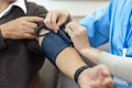 Nurses or caregivers take care of elderly by helping to check their blood pressure Royalty Free Stock Photo