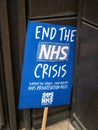 A nurses NHS protest placard left against a hospital building.