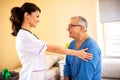 Nursing home doctor providing care to a senior man resident Royalty Free Stock Photo