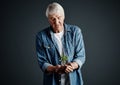 Nurturing growth. Studio shot of a handsome mature man holding a budding plant against a dark background. Royalty Free Stock Photo