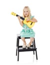 Nurturing her talent. Studio shot of a cute little girl playing with her toy guitar against a white background. Royalty Free Stock Photo