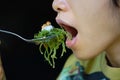 A Close up photo of mouth eat the seaweed on a spoon. In Bali, its called bulung Royalty Free Stock Photo