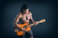 Nuscular topless young black man playing guitar