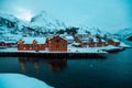 Nusfjord, small fishing village in Norway, during amazing winter evening, ships, snow and yellow cabins.
