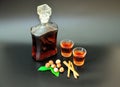 Nut cinnamon liqueur, strong homemade alcohol in a bottle and two glasses on a black background Royalty Free Stock Photo