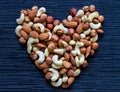 Nut heart on dark background. Almond, cashew, hazelnut nuts. Organic food rustic banner template.