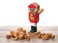Nutcracker with inshell and cracked nuts on wooden surface Royalty Free Stock Photo