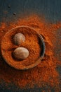 Nutmeg whole and ground. Nutmeg fruits in nutmeg powder in a cup on a black slate background. View from above .Spices Royalty Free Stock Photo