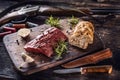 Nutrient rich raw deer venison prepared for a cooking process on a rustic wooden desk with roasted garlic, rosemary and huntig Royalty Free Stock Photo