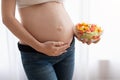 Nutrition For Healthy Pregnancy. Pregnant Woman Holding Vegetable Salad Bowl Near Belly