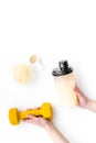 Nutrition for muscle growth. Scoop of protein near shaker and dumbbell on white background top view copy space Royalty Free Stock Photo