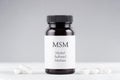 Nutritional supplement msm, sulfur, methylsulfonylmethan bottle and capsules on gray Royalty Free Stock Photo