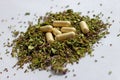 Nutritional supplements pills and capsules on dried herbs background. Alternative herbal medicine, naturopathy and homeopathy