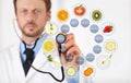 Nutritionist Doctor hand with a stethoscope touch screen with blue medical symbols, fruits and vegetables icons, healthy food diet Royalty Free Stock Photo