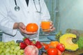 Nutritionist doctor holding fruits and vegetable on desk to instruction Royalty Free Stock Photo