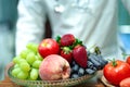 Nutritionist doctor holding orange with various fruits and vegetables. Royalty Free Stock Photo