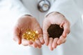 Nutritionist holding omega pills in one hand and dry tea in the other hand over white background. Royalty Free Stock Photo