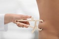 Nutritionist measuring man`s body fat layer with caliper