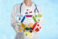 Nutritionist`s recommendations. Doctor with healthy products on blue background, closeup