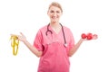 Nutritionist woman holding measuring tape and training weights Royalty Free Stock Photo