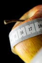 Nutritious apple, wrapped with a measuring tape