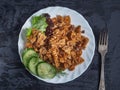 Nutritious breakfast. A paste of flour with dark Turkey meat, slices of cucumber and dining fork. Serve on a dark background Royalty Free Stock Photo