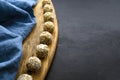 nutritious energy balls consisting of nuts, oatmeal, honey, dried fruits on a wooden board on a black slate background