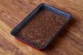 Nutritious flaxseed on baking tray over wooden background, selective focus, shallow depth of field.