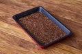 Nutritious flaxseed on baking tray over wooden background, selective focus, shallow depth of field.