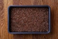 Nutritious flaxseed on baking tray over wooden background, selective focus, shallow depth of field.