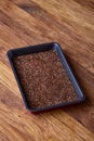 Nutritious flaxseed on baking tray over wooden background, selective focus, shallow depth of field.