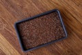 Nutritious flaxseed on baking tray over wooden background, selective focus, shallow depth of field.