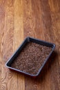 Nutritious flaxseed on baking tray over wooden background, selective focus, shallow depth of field.