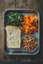 Nutritious lunch tray with vegetables, bread, and beans on rustic wooden table Royalty Free Stock Photo