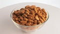 Nuts almond rotate are on a table in a plate. Snack in transparent dish on an isolated white background are spinning Royalty Free Stock Photo