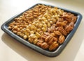 Nuts almonds, pistachios and pecans on black plate, close-up, set.