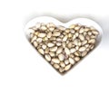 Nuts arranged in heart on background. Healthy Food image close up pistachios on the cup plate. Love Texture on white grey table