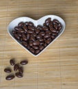 Nuts arranged in heart shape on background. Food image close up candy, chocolate milk, extra dark almond nuts. Love Texture