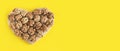 Nuts banner background. Organic walnuts are shaped like a heart on a minimal background. Healthy food for the heart, useful