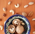 Nuts in bowl on wooden background, top view with copyspace. Royalty Free Stock Photo