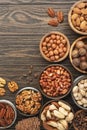 Nuts in bowls. Walnuts, pistachios, pecans, macadamia, almonds and other. Healthy food snacks mix on wooden background, top view Royalty Free Stock Photo