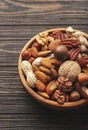 Nuts in bowls. Walnuts, pistachios, pecans, macadamia, almonds and other. Healthy food snacks mix on wooden background, top view Royalty Free Stock Photo