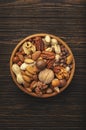 Nuts in bowls. Walnuts, pistachios, pecans, macadamia, almonds and other. Healthy food snacks mix on wooden background, top view Royalty Free Stock Photo