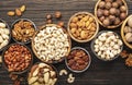 Nuts in bowls. Walnuts, pistachios, pecans, macadamia, almonds and other. Healthy food snacks mix on wooden background, top view Royalty Free Stock Photo