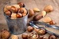 nuts in a bucket and a steel nut cracker on burlap. Close-up, selective focus Royalty Free Stock Photo