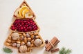Nuts, cranberries and dried fruit in Christmas tree-shaped bowl on light background Royalty Free Stock Photo