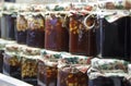 Nuts filled with honey in glass jars are on wooden shelves at the food exhibition. Healthy food Royalty Free Stock Photo