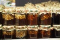 Nuts filled with honey in glass jars are on wooden shelves at the food exhibition. Healthy food Royalty Free Stock Photo