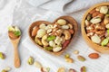 Nuts mixed in heart wooden bowl on marble table with linen cloth Royalty Free Stock Photo